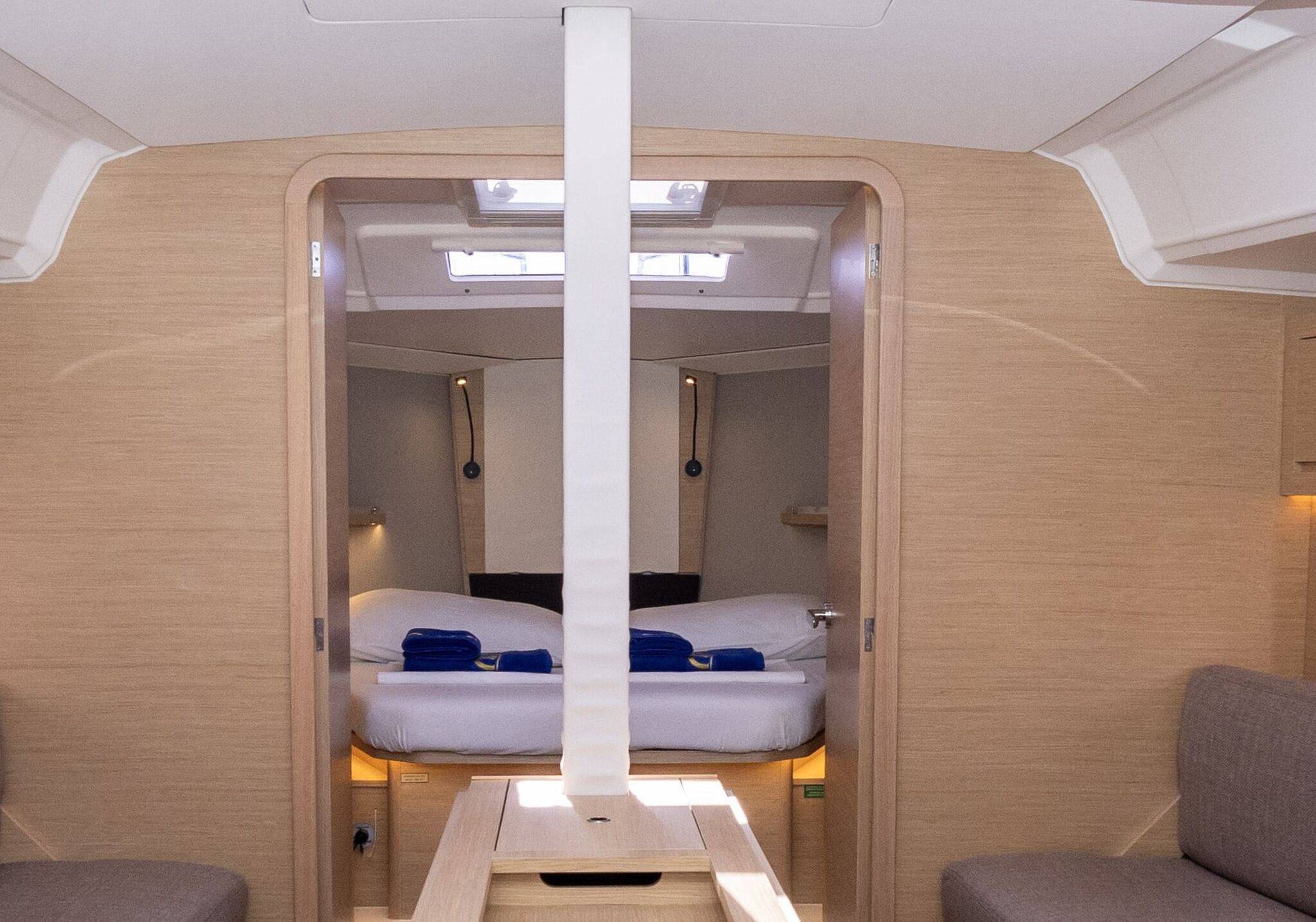 Een compact interieur met twee bedden, een centrale tafel en verlichting boven.