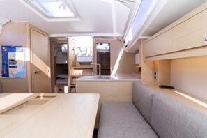 A compact RV interior with a kitchenette, a dining area, and a seating space. - Sun-Kissed Sailing Adventure in Zadar, Croatia (Biograd na moru)