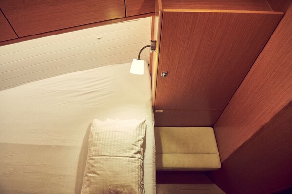 A compact bed with a headboard, a bedside lamp, and a small storage cabinet. - Sun-Kissed Sailing Adventure in Istria, Croatia (Pula)