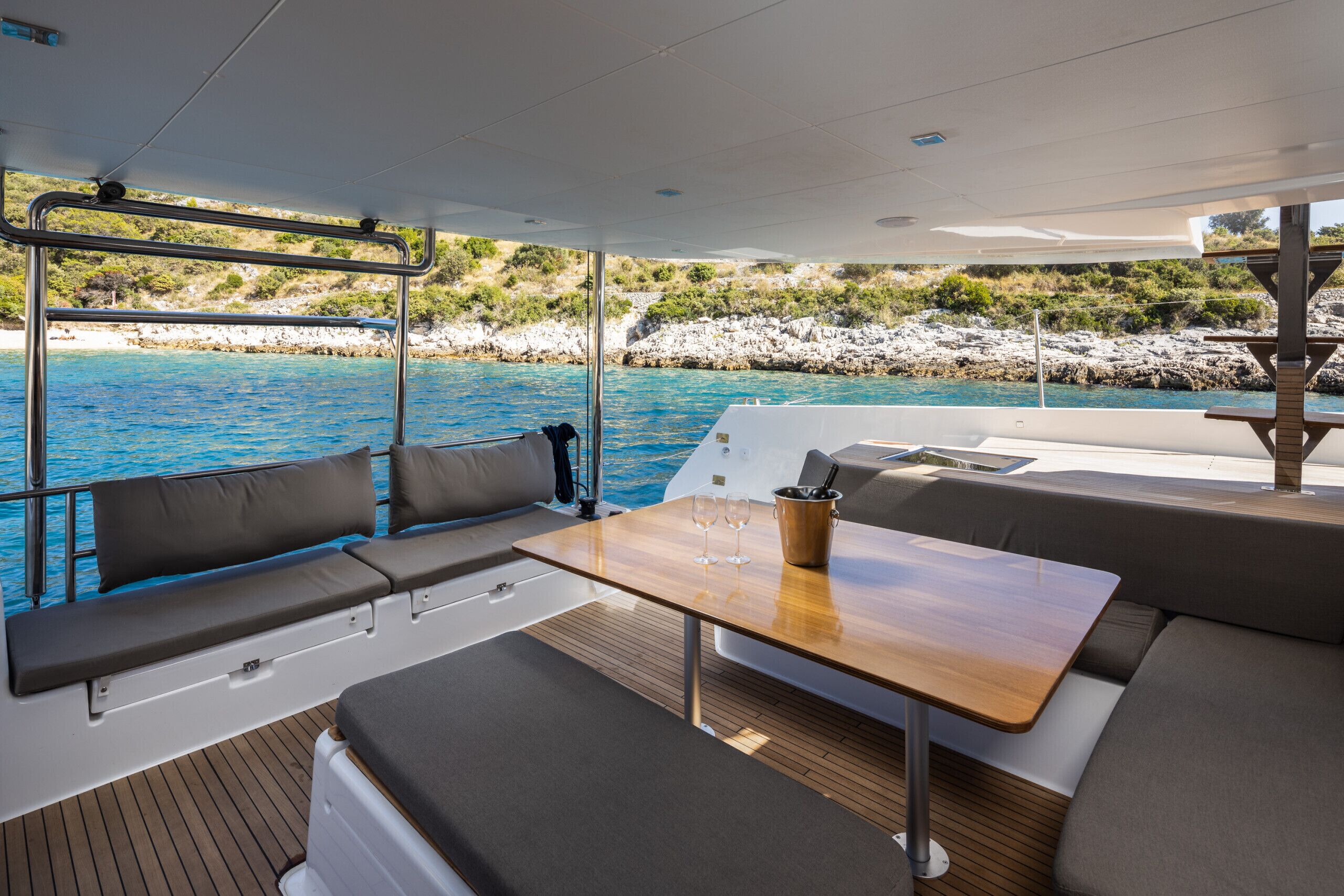Un pont de bateau aménagé avec des sièges, une table et une vue sur la mer.