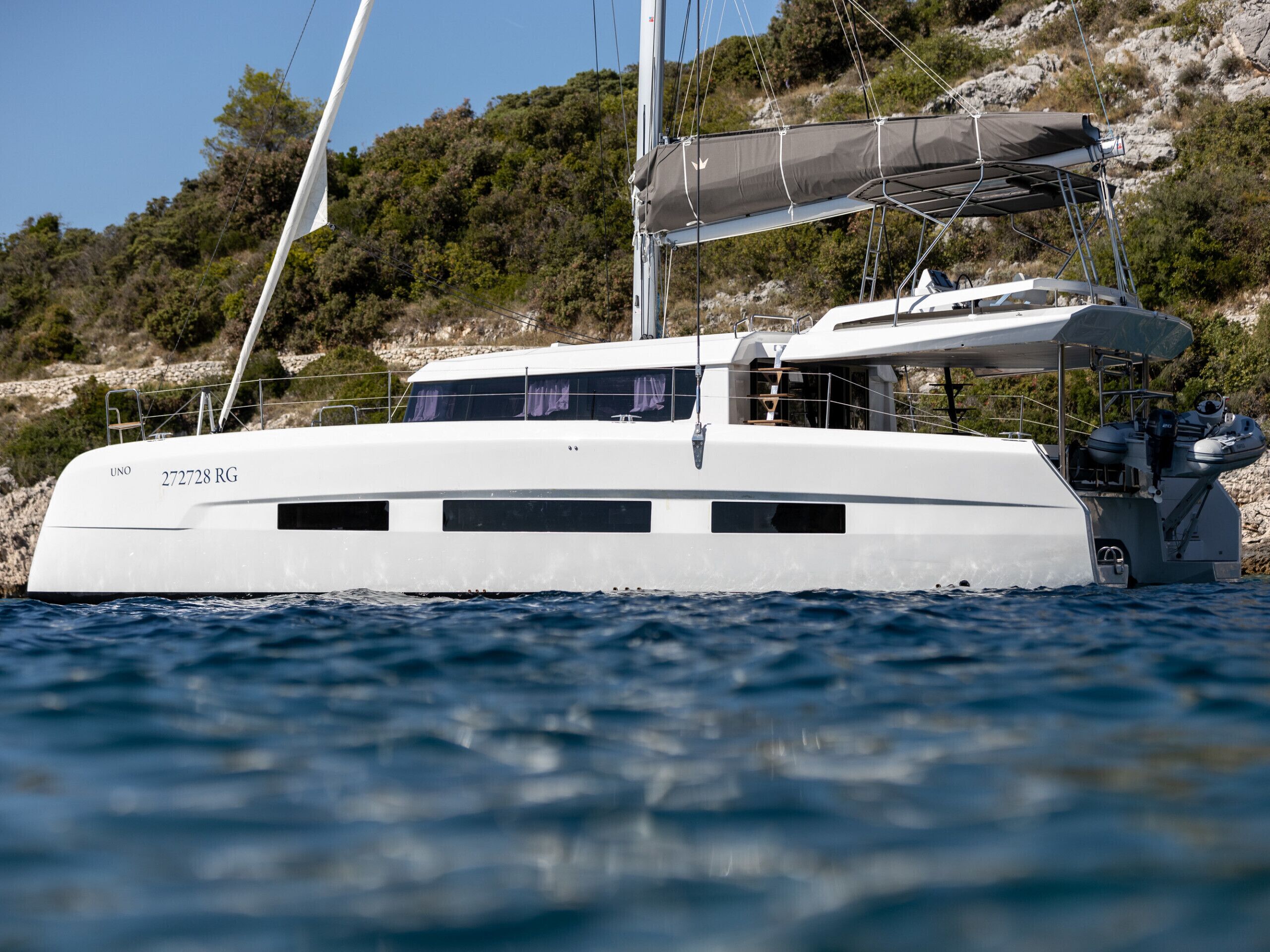 A large white yacht with the registration number 272728 RG, a covered deck area, and a cabin with windows.