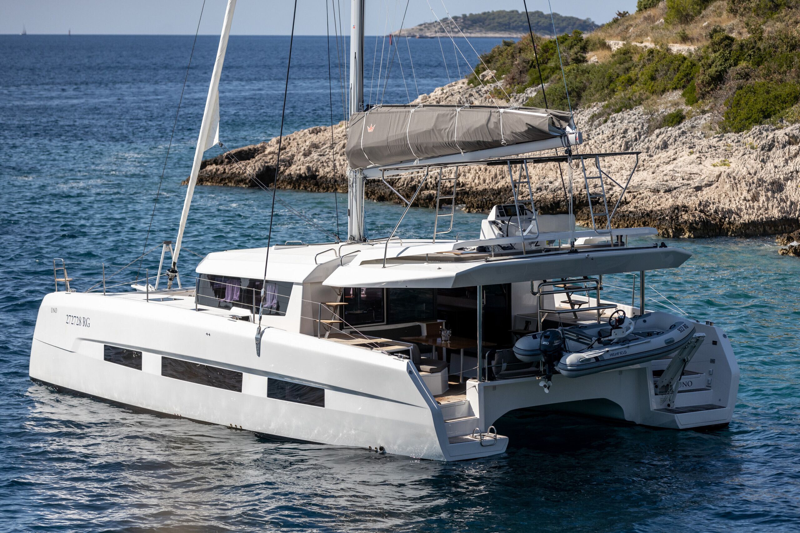 Un yacht blanc doté d’un pont couvert, d’une cabine et d’un moteur hors-bord.