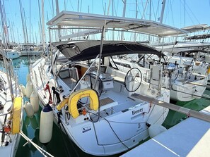 Ein Yachthafen mit mehreren angestaubten Booten, mit einer überdachten Deckfläche mit Sitzgelegenheiten und Steuerpult.