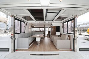 A modern interior with a dining area, seating, and a view of the marina. - Sun-Kissed Sailing Adventure in Zadar, Croatia (Bibinje)