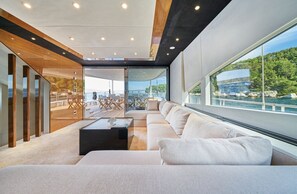 En modern inredning med ett stort fönster, en soffa och en matplats.