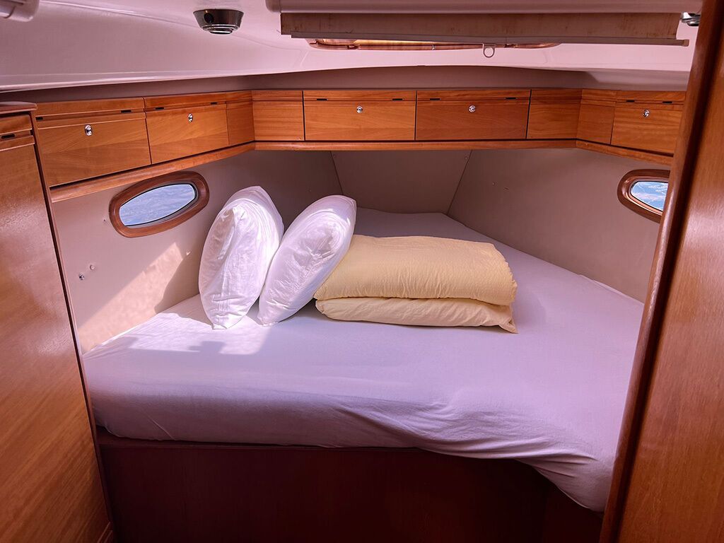 Een compact vakantiehuisje met een bed, opbergvakken en een klein raam.