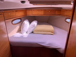 A compact cabin with a bed, storage compartments, and a small window. - Sun-Kissed Sailing Adventure in Northern Croatia (Punat)