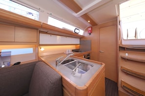 A compact kitchen with a sink, stove, and cabinets. - Sun-kissed Sailing Adventure in Split-Dalmatia, Croatia (Trogir)