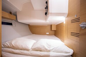 A compact, well-lit room with a single bed, wooden headboard, and a built-in storage unit. - Sun-Kissed Sailing Adventure in Istria, Croatia (Pula)