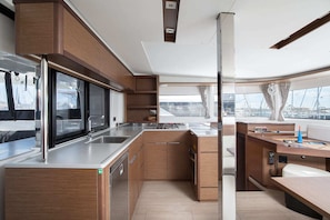 Eine moderne Küche mit Edelstahlgeräten, Holzschränken und Blick auf den Yachthafen.