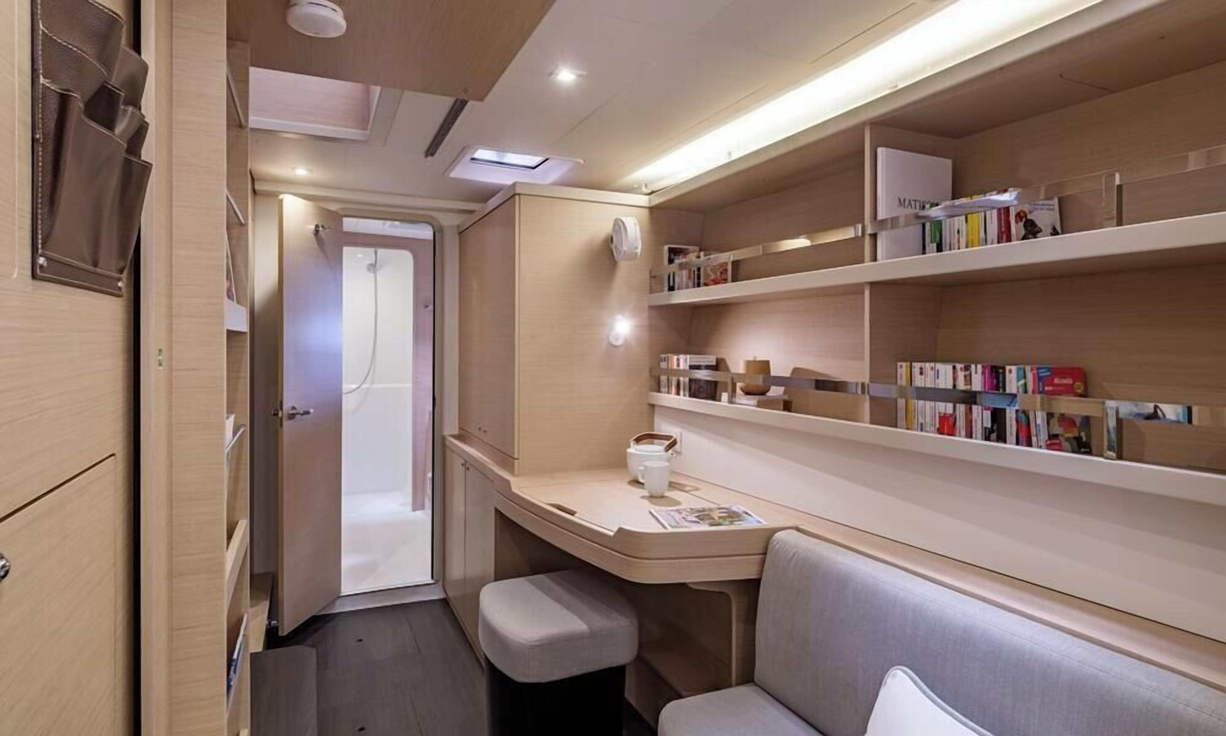 A compact, well-lit room with a desk, bookshelves, and a seating area.