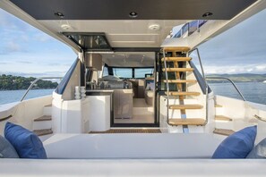 A yacht's interior with a dining area, kitchen, and a staircase leading to the upper deck. - Sun-Kissed Sailing Adventure in Zadar, Croatia (Bibinje)
