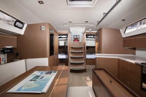 A compact, well-organized interior with a central table displaying a map, a bunk area with a control panel, and a small kitchenette.