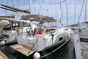 A marina with several sailboats docked, including one named 'Pura Vida.'