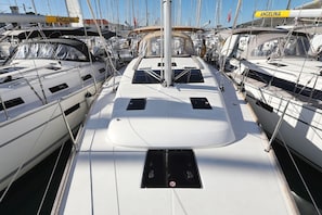 Ein Yachthafen mit mehreren Segelbooten, die an den Stegen liegen, mit einem zentralen Weg und einem Mast.