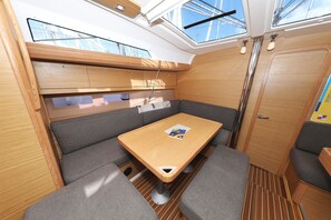 Ein gemütlicher Innenraum mit Holztisch, gepolsterten Sitzmöglichkeiten und einem Oberlicht.