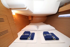 Ein gemütliches Schlafabteil mit Etagenbett, zwei Handtüchern mit einem Logo und einem kleinen Fenster.