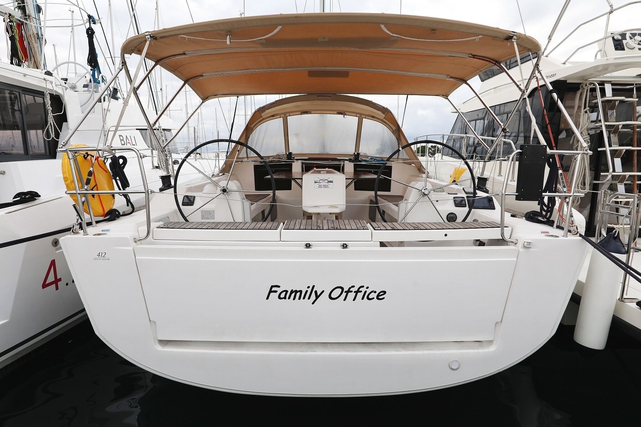 Een boot genaamd 'Family Office' met een afdak, een stuurwiel en een reddingsboei.