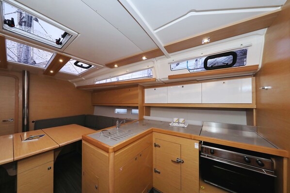 A compact kitchen with a sink, stove, and cabinets. - Sun-kissed Sailing Adventure in Split-Dalmatia, Croatia (Trogir)