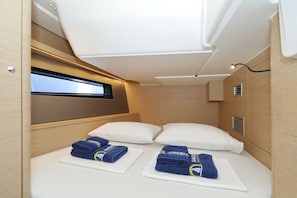 Ein gemütliches Blockhaus mit Bett, Kissen, einem Fenster und einer kleinen Ablage.