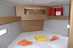 Ein Etagenbett mit einer Unterliege, einem kleinen Fenster und einer roten Tasche auf der Oberliege.