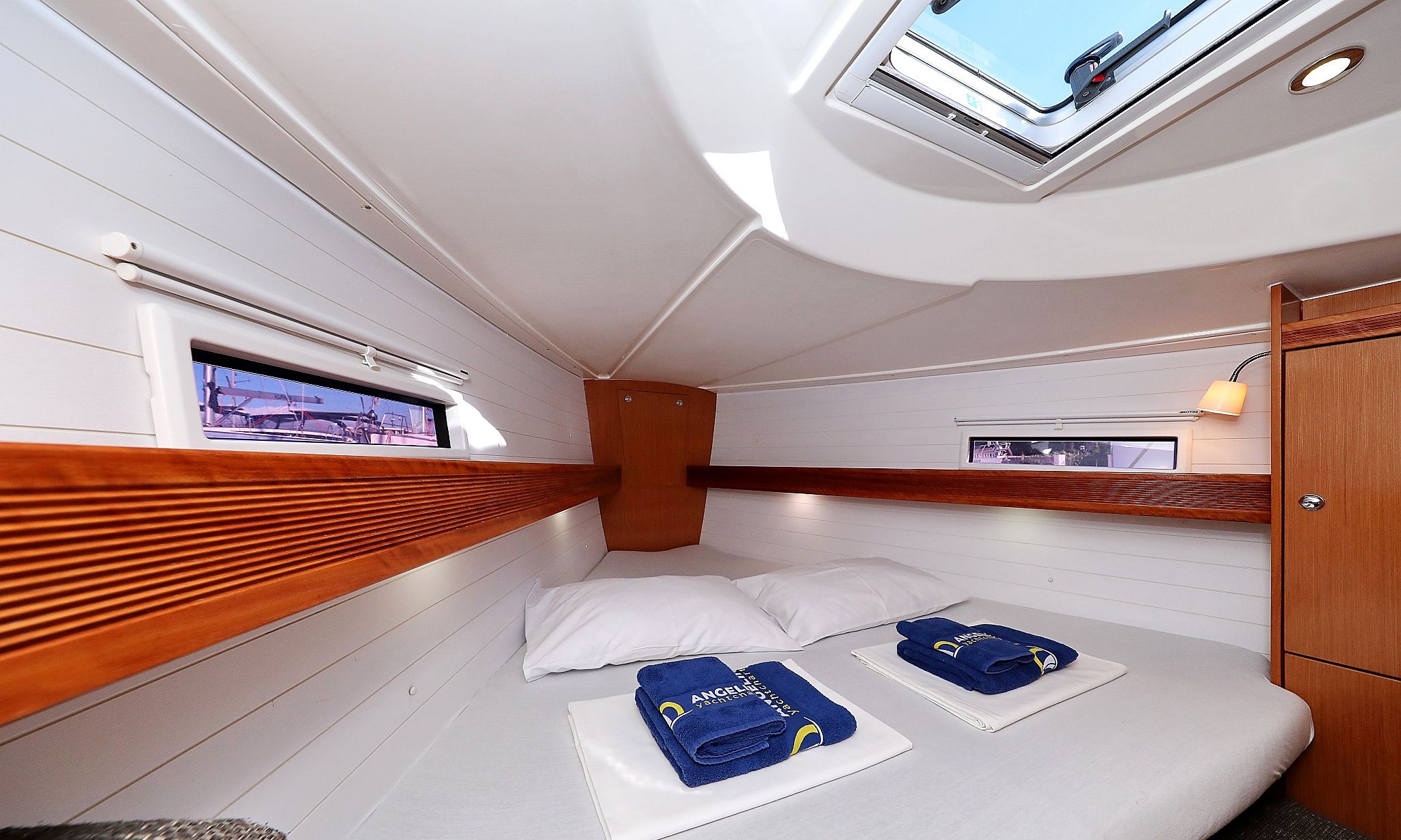 A compact cabin with a bunk bed, a small window, and a skylight.