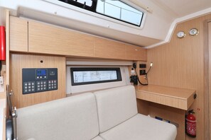 A compact interior with a control panel, a cushioned seating area, and a small shelf. - Sun-Kissed Sailing Adventure in Zadar, Croatia (Biograd na moru)