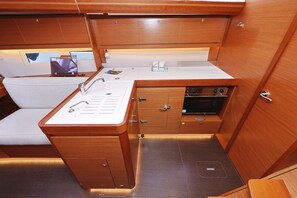 A compact galley with a sink, stove, and storage cabinets. - Sun-kissed Sailing Adventure in Split-Dalmatia, Croatia (Trogir)