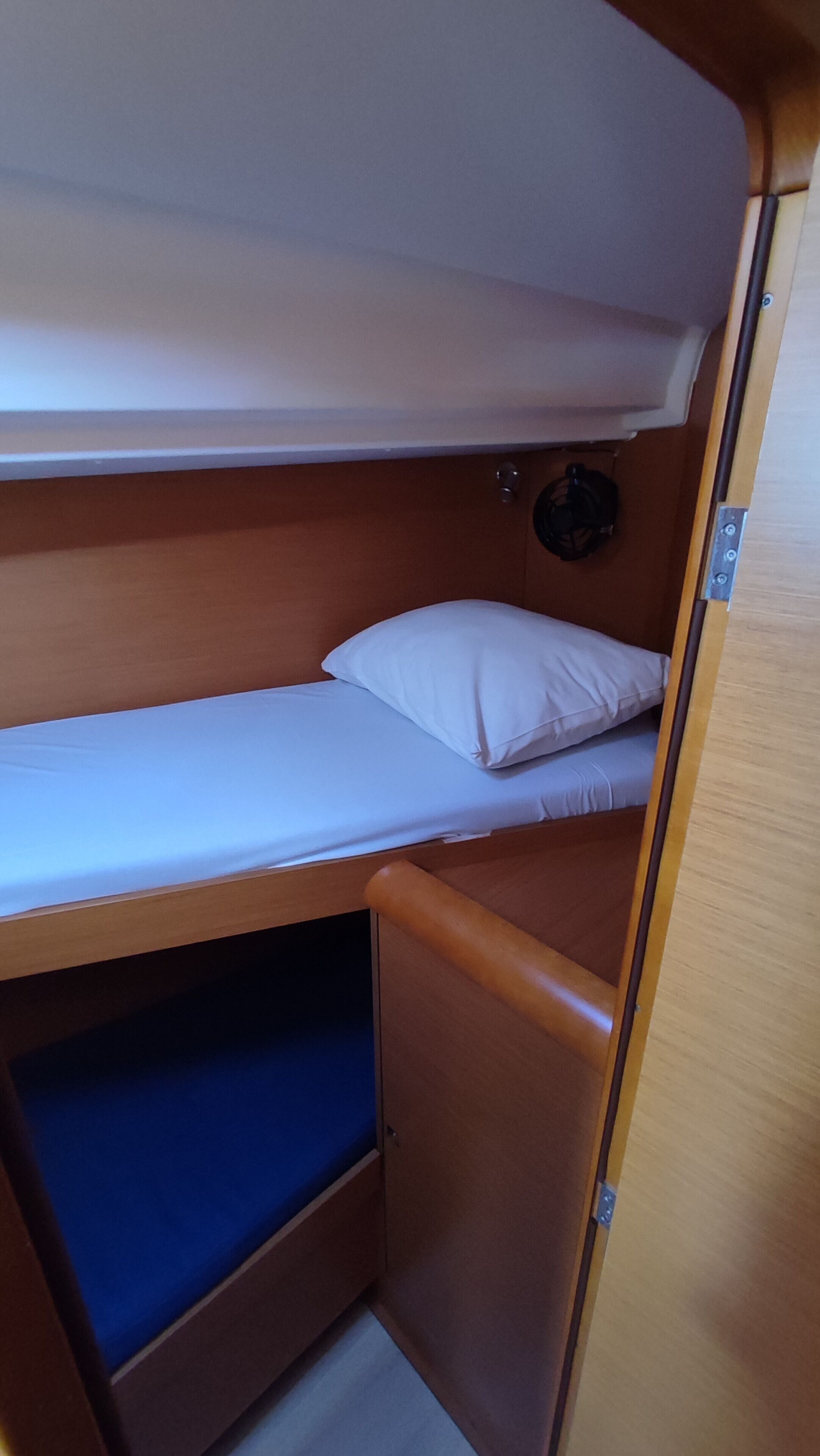 A bunk bed with a lower bunk and a small storage space underneath.