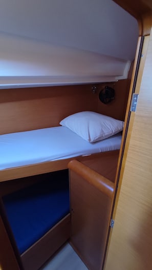 Ein Stockbett mit unterem Bett und einem kleinen Stauraum darunter.