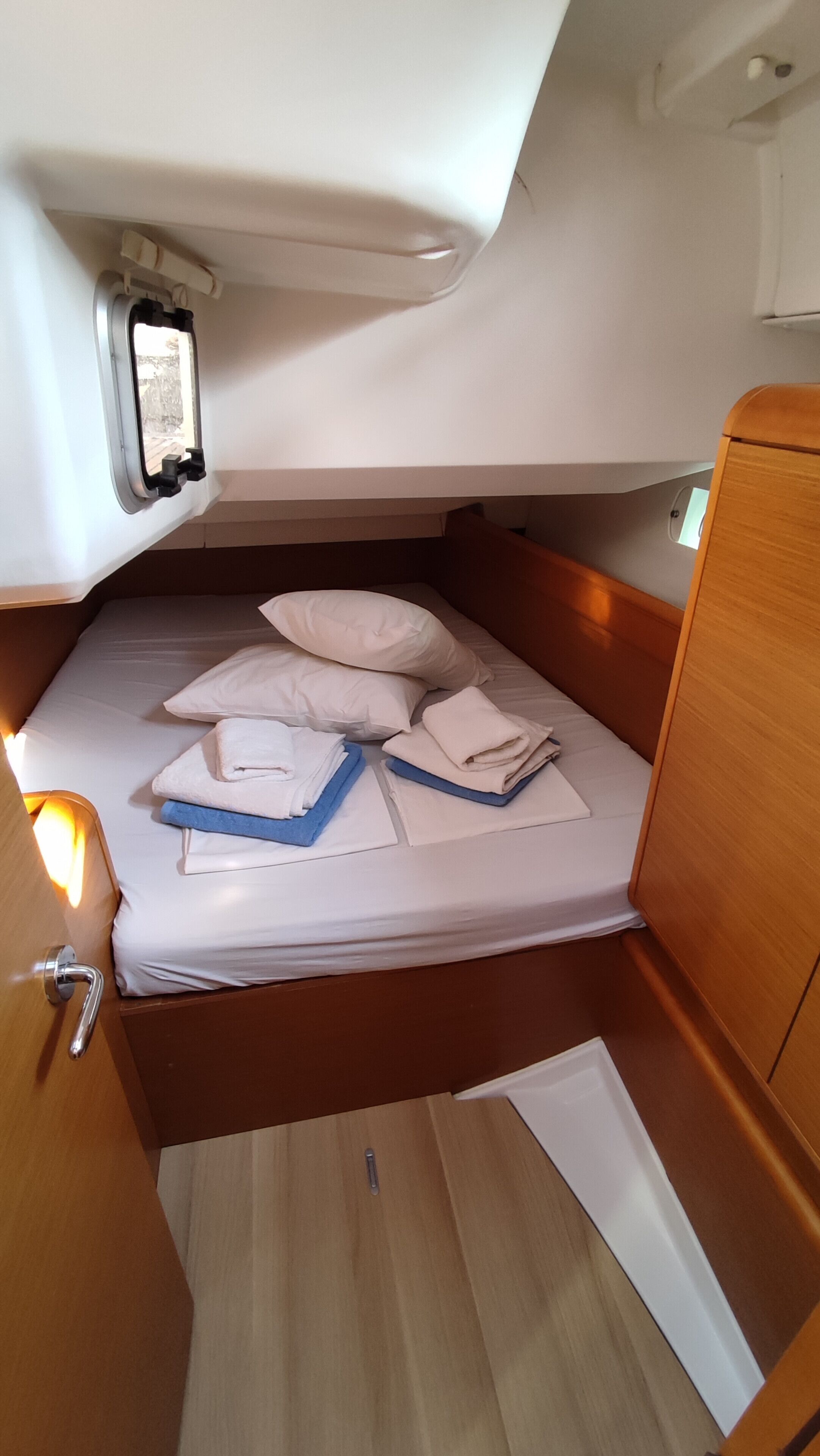 Una cabaña pequeña con cama, almohadas y toallas ordenadas.