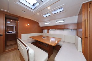 A compact interior with a wooden table, cushioned seating, and skylights. - Sun-Kissed Sailing Adventure in Zadar, Croatia (Biograd na moru)