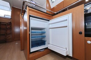 A kitchen with wooden cabinets, a white refrigerator, and a stainless steel oven. - Sun-Kissed Sailing Adventure in Zadar, Croatia (Biograd na moru)