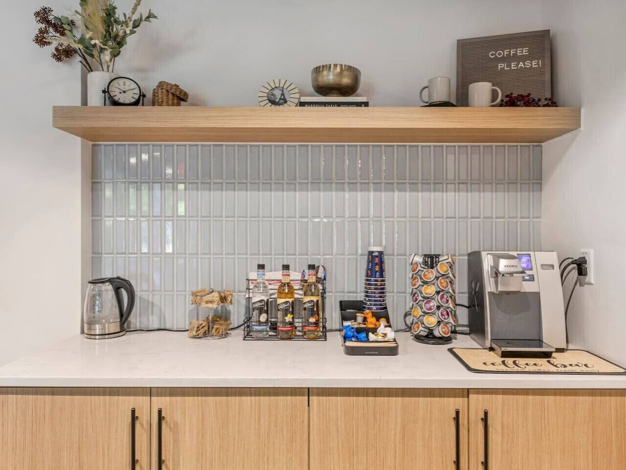 A kitchen counter with a coffee machine, a kettle, and various coffee-related items.