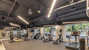 A gym with various exercise equipment, large windows, and a modern ceiling design. - Quiet condo w/ balcony, fast Wi‑Fi & gym (Salt Lake City)