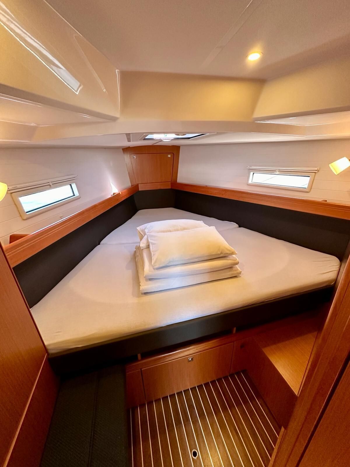 Ein kleines, gemütliches Abteil mit Bett, Stauraumschränken und einem kleinen Fenster.