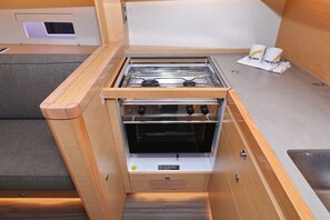 Eine kleine Küchenzeile mit Einbauherd, Backofen und einer Arbeitsfläche.
