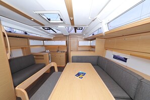 Ein kompaktes Wohnmobil-Interieur mit Essbereich, Sitzgelegenheiten und einer Küchenzeile.