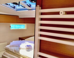 Eine Hütte mit einem Bett, einem an der Wand montierten Fernseher und einem Fenster.