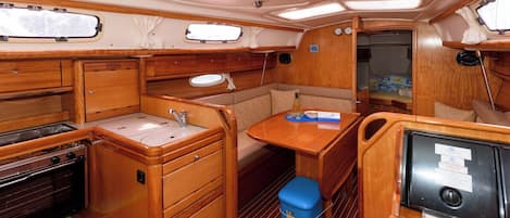 A compact galley with a stove, sink, and storage cabinets.