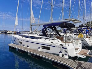 Ein Yachthafen mit mehreren Segelbooten an den Stegen, mit einem hölzernen Deck und einem überdachten Bereich.