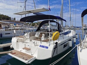 A yacht named 'SEADUCTION' docked at a marina with other boats, a covered deck, and a view of the marina in the background. - Sun-Kissed Sailing Adventure in Zadar, Croatia (Drage)