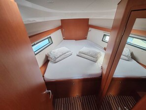 A compact cabin with a single bed, a window, and a door. - Sun-Kissed Sailing Adventure in Zadar, Croatia (Drage)