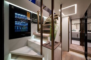 Eine moderne Treppe mit digitalem Display, einer Pflanze und Blick auf ein Schlafzimmer.