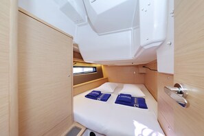 A compact, well-lit interior with a bed, storage cabinets, and a small window. - Sun-Kissed Sailing Adventure in Zadar, Croatia (Bibinje)