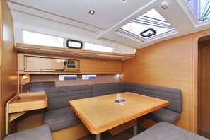 A compact interior with a table, bench seating, a control panel, and skylights. - Sibenik Sun and Beach Sailing Extravaganza: A Croatian Coastal Adventure (Vodice)