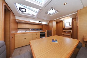 A compact kitchen with wooden cabinetry, a central island, and skylights. - Sibenik Sun and Beach Sailing Extravaganza: A Croatian Coastal Adventure (Vodice)