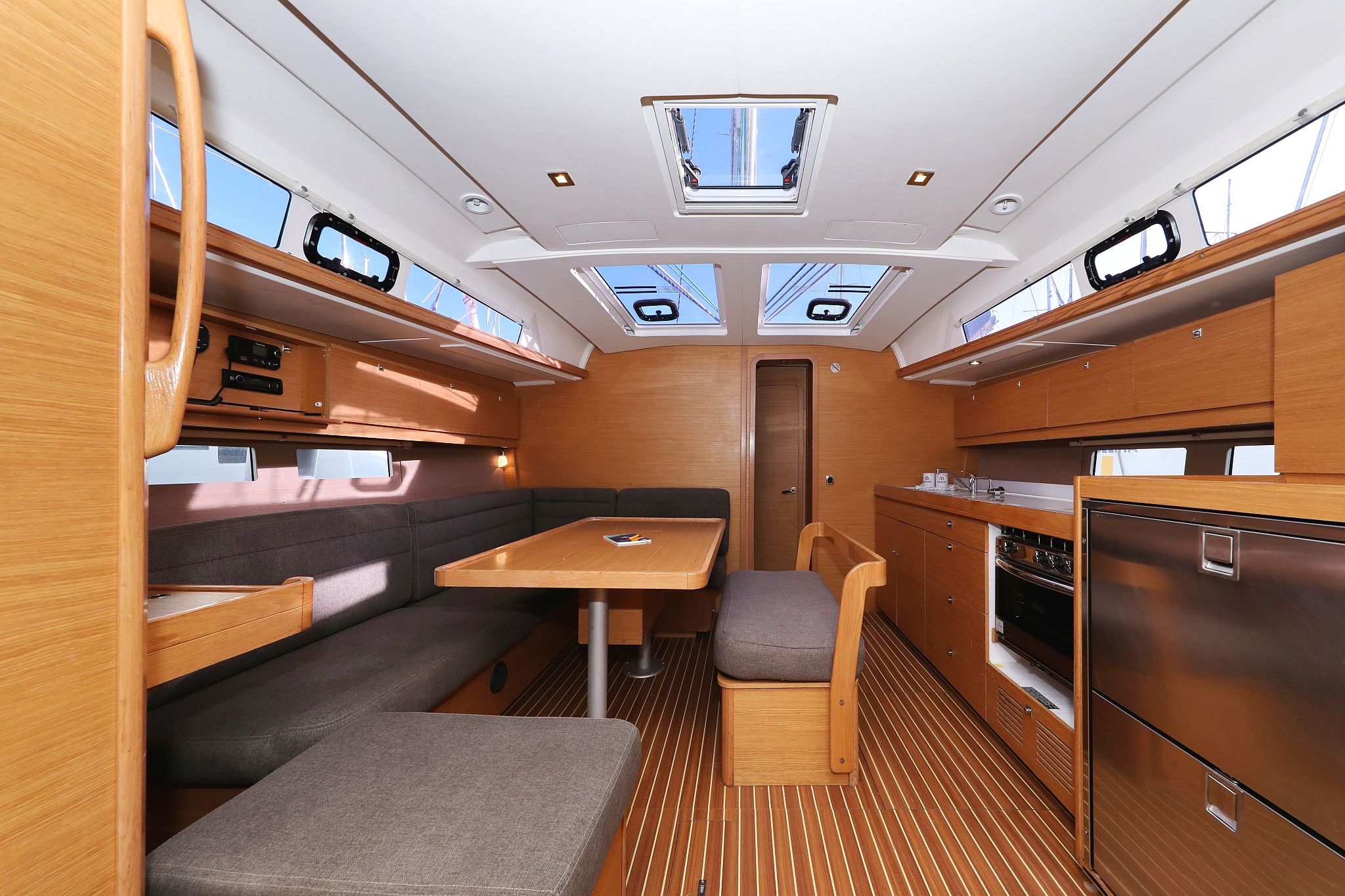 A compact galley with a table and seating, a stove, and a refrigerator.