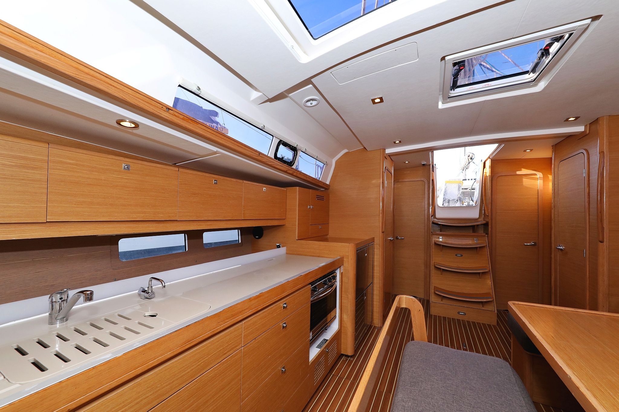 A compact galley with wooden cabinetry, a sink, and a small oven.