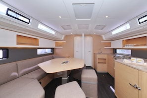 Ein kompaktes Wohnmobil-Interieur mit einer Küchenzeile, einer Sitzecke und einer Tür zum Außenbereich.